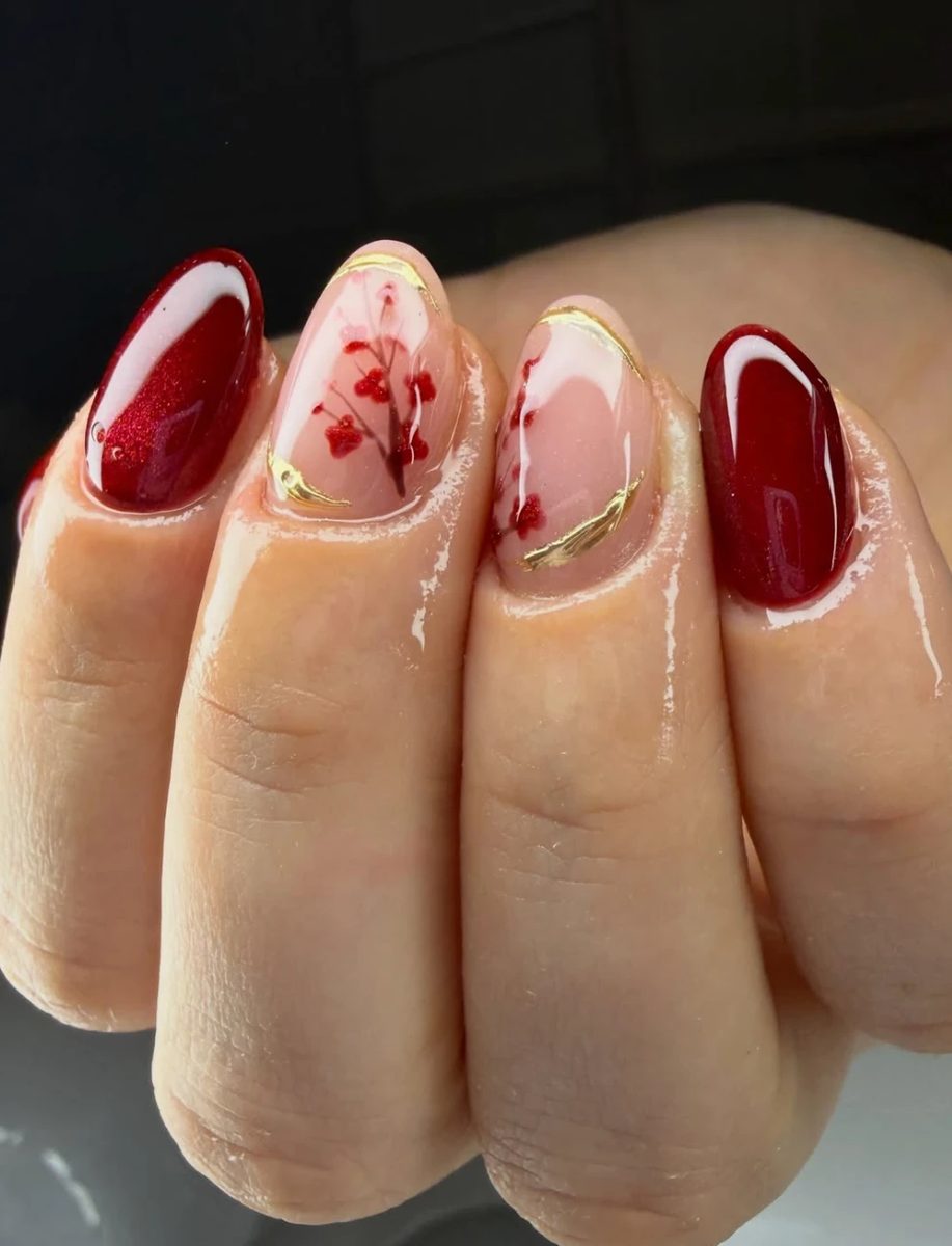 Nageldesign in Rot mit Blütenmotiv und Goldakzenten